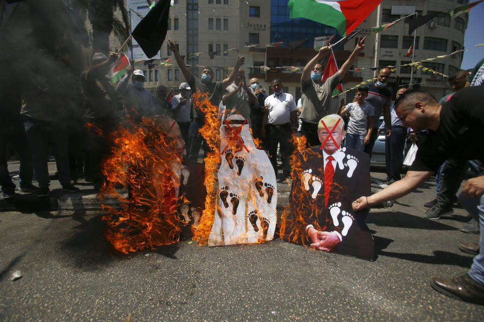 Palestinians burn pictures of U.S. President Donald Trump, Abu Dhabi Crown Prince Mohammed bin Zayed al-Nahyan and and Israeli Prime Minister Benjamin Netanyahu during a protest against the United Arab Emirates' deal with Israel, in the West Bank city of Nablus, Friday, Aug. 14, 2020.(AP Photo/Majdi Mohammed)