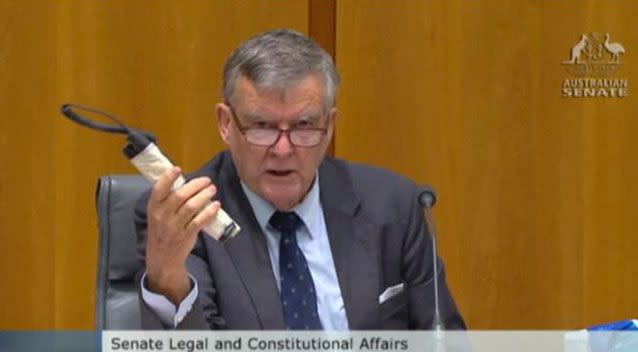 Senator Bill Heffernan holding a 'pipe bomb' in a parliamentary hearing.