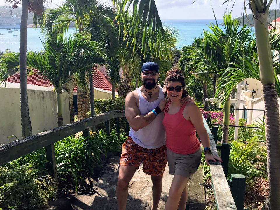 Author Felicia Slattery and her husband in St. Thomas i front of palm trees