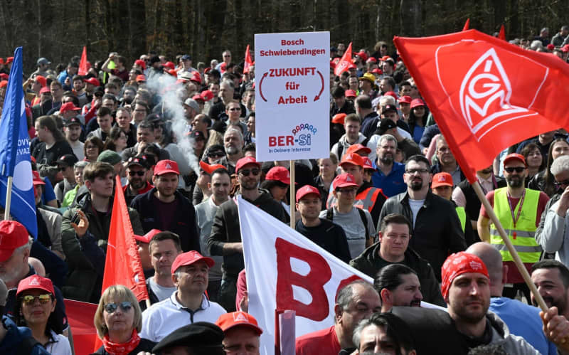 Employees of the Bosch industrial group gather for a rally organized by IG-Metall and the Bosch General Works Council in front of the Bosch headquarters. More than 10,000 employees at German engineering and technology firm Bosch protested outside the company's headquarters on Wednesday against planned job cuts. Bernd Weißbrod/dpa