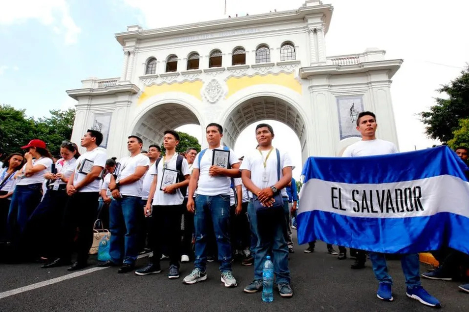 Joven sujeta una bandera de El Salvador.