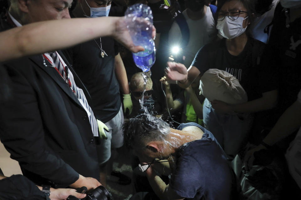 A protester pours water on a detained man, who protesters claimed was a police officer from mainland China, during a demonstration at the Airport in Hong Kong, Tuesday, Aug. 13, 2019. (Photo: Kin Cheung/AP)