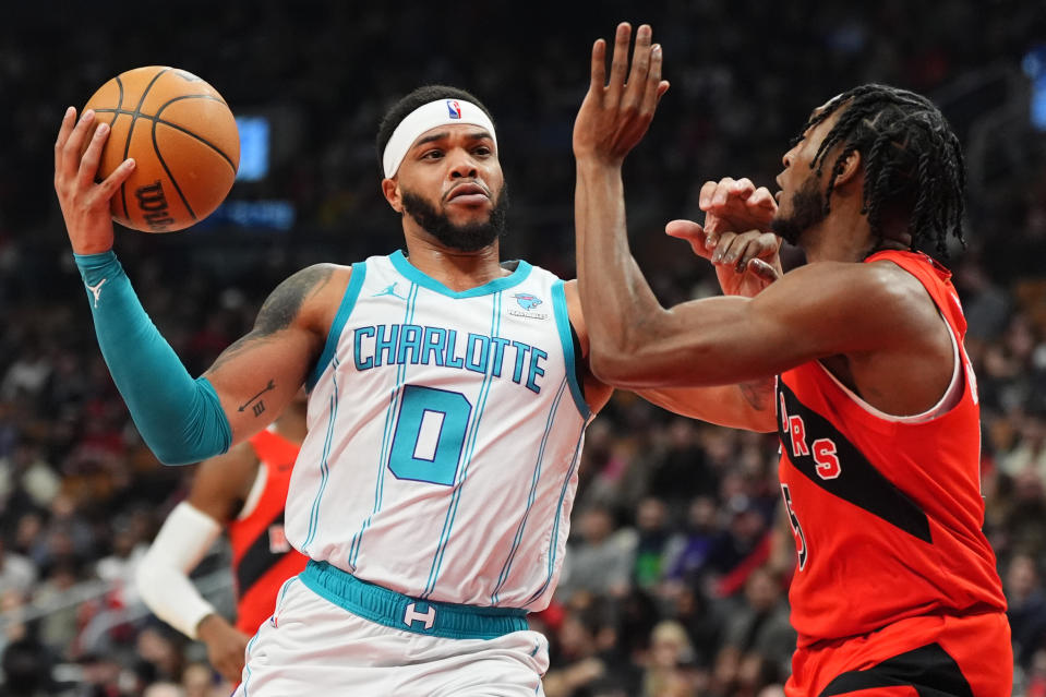 Charlotte Hornets forward Miles Bridges (0) drives upcourt as Toronto Raptors guard Immanuel Quickley, right, defends during first-half NBA basketball game action in Toronto, Sunday, March 3, 2024. (Frank Gunn/The Canadian Press via AP)