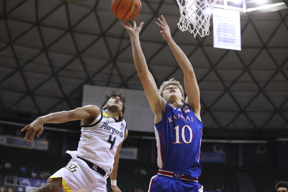Kansas guard Johnny Furphy (10) shoots against Marquette guard Stevie Mitchell (4 during the second half of an NCAA college basketball game Tuesday, Nov. 21, 2023, in Honolulu. (AP Photo/Marco Garcia)