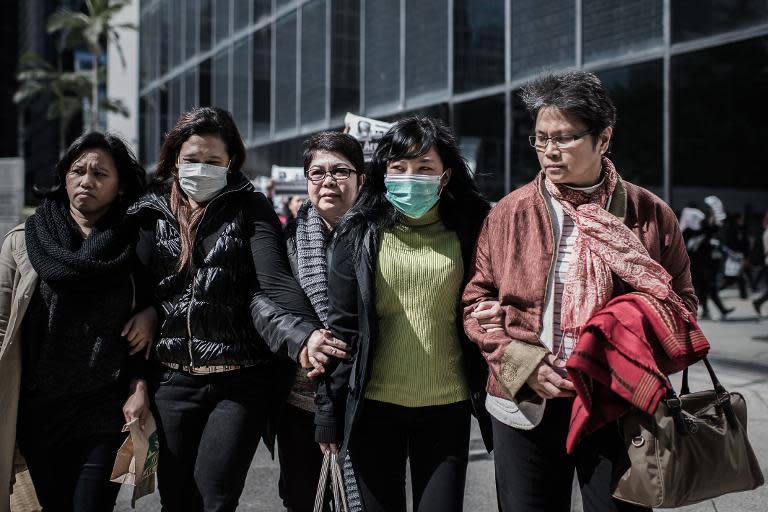 Indonesian former maid Erwiana Sulistyaningsih (2nd R) is escorted as she walks out of a court after giving evidence, in Hong Kong, on January 20, 2015