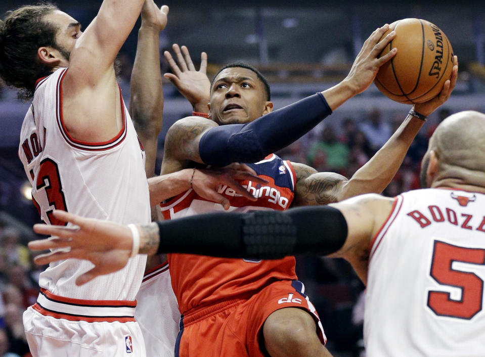 Washington Wizards guard Bradley Beal (3), center, drives to the basket against Chicago Bulls center Joakim Noah, left, and forward Carlos Boozer (5) during the first half in Game 1 of an opening-round NBA basketball playoff series in Chicago, Sunday, April 20, 2014. (AP Photo/Nam Y. Huh)