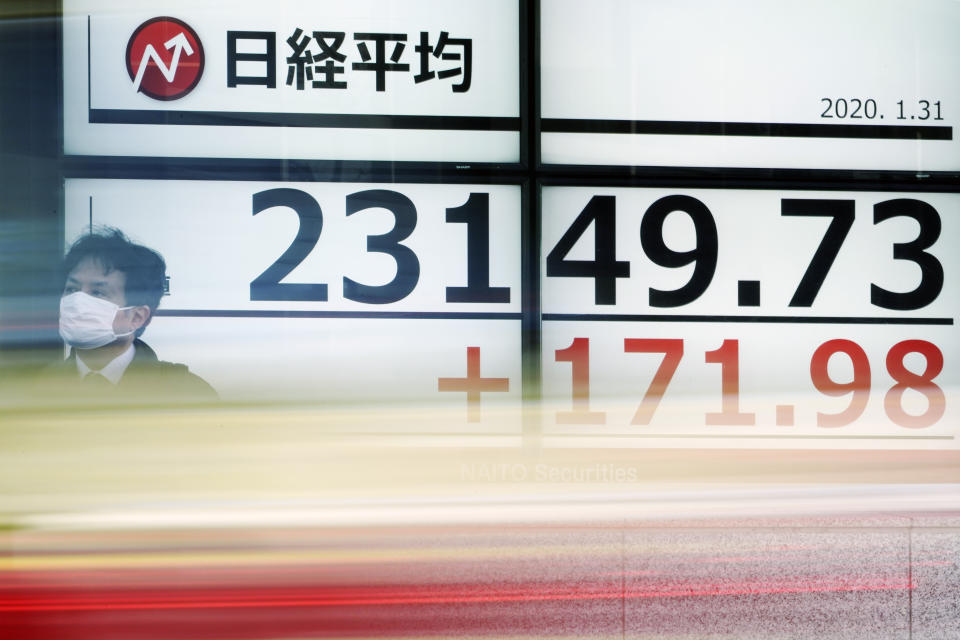 A man walks past an electronic stock board showing Japan's Nikkei 225 index at a securities firm in Tokyo Friday, Jan. 31, 2020. Shares are mixed in Asia after the World Health Organization declared the outbreak of a new virus that has spread from China to more than a dozen countries a global emergency. (AP Photo/Eugene Hoshiko)
