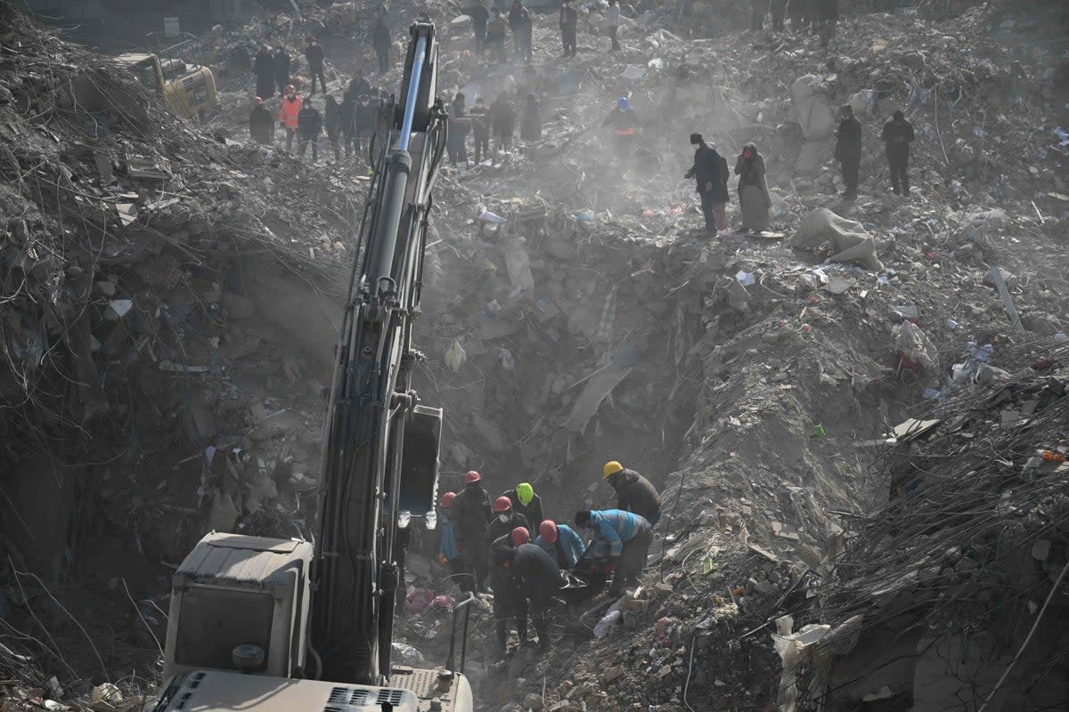 Rescuers remove a body from rubble in Kahramanmaras, Turkey on Tuesday (AFP via Getty Images)