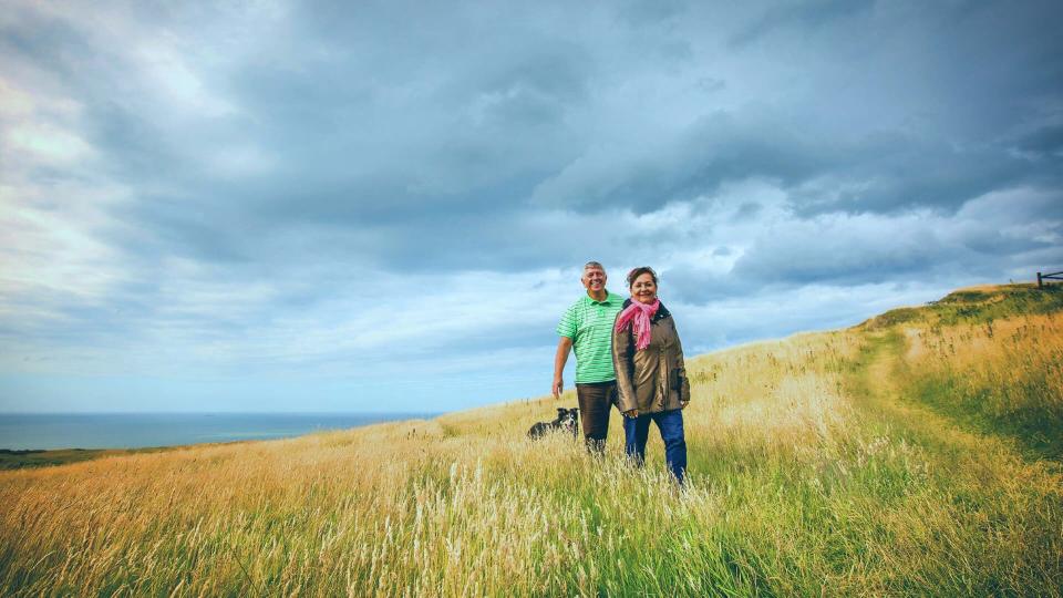 active couple on a walk through long grass