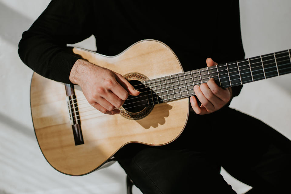 An up-close image of a person holding a guitar