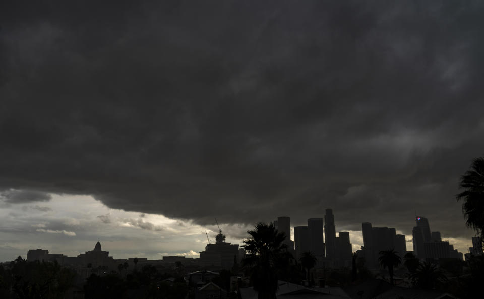 FILE - In this Saturday, Jan. 23, 2021, file photo, heavy clouds move over Los Angeles city skyline. California’s hopes for a wet “March miracle” did not materialize and a dousing of April 2021 showers may as well be a mirage at this point. The state appears in the midst of another drought only a few years after a punishing 5-year dry spell dried up rural wells, killed endangered salmon, idled farm fields and helped fuel the most deadly and destructive wildfires in modern state history. (AP Photo/Damian Dovarganes, File)