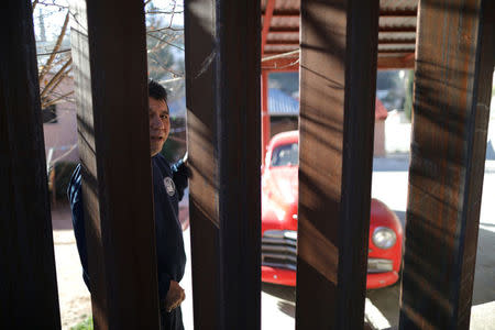 A man in Nogales, Sonora, Mexico looks through the U.S. border fence into Nogales, Arizona, U.S., January 31, 2017. REUTERS/Lucy Nicholson