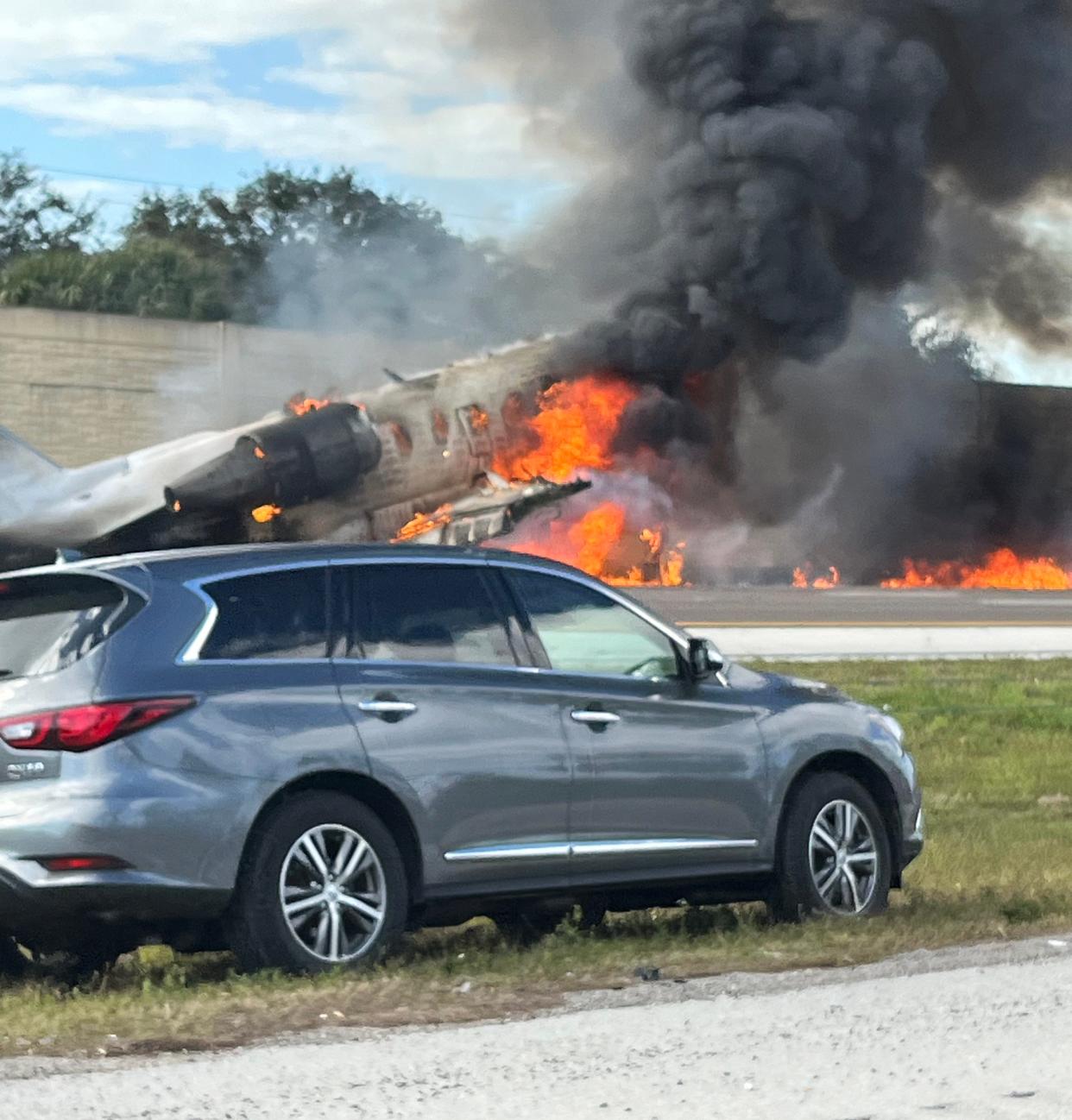 A passing motorist's view of the fiery crash Friday of a Hop-A-Jet Bombardier Challenger 600 jet along Interstate 75 near Naples in Collier County, southwest Florida. Two of the five people aboard were reported killed, and three others were identified as survivors. The private charter jet departed Ohio State University Airport about 12:30 p.m. Friday bound for Fort Lauderdale, Florida, but reported an emergency and was attempting to land at Naples airport. The pilot radioed in his last transmission that the aircraft had lost both engines and would not make it to the airport.