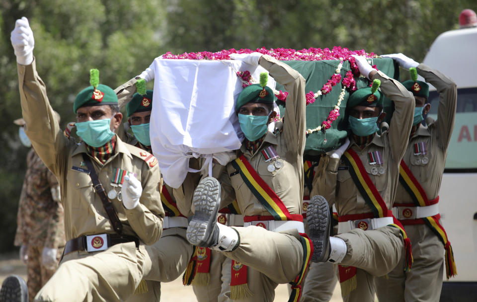 FILE - In this June 1, 2020, file, photo, Pakistani soldiers carry the coffin of their colleague who died in the crash of a state-run Pakistan International Airlines plane May 22, during his funeral in Karachi, Pakistan. The European Union’s aviation safety agency said Tuesday, June 30, 2020 that Pakistan’s national airline will not be allowed to fly into Europe for at least six months after the country’s aviation minister revealed that nearly a third of Pakistani pilots had cheated on their pilot’s exams. (AP Photo/Fareed Khan File)