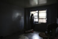 Sharawn Vinson looks out the window of her 16th-floor apartment as she talks on the phone with the New York Police Department's Chief of Community Affairs Jeffrey Maddrey on Thursday, Aug. 13, 2020, in the Brooklyn borough of New York. At the peak of the coronavirus pandemic this spring, Vinson often woke up crying. A recurring thought was making the unemployed single mother desperate: That her kids could go hungry. (AP Photo/Jessie Wardarski)