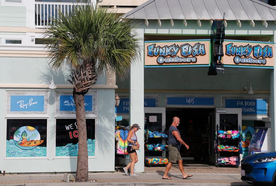 A couple walks past one of the beach shops on Tybee Island.