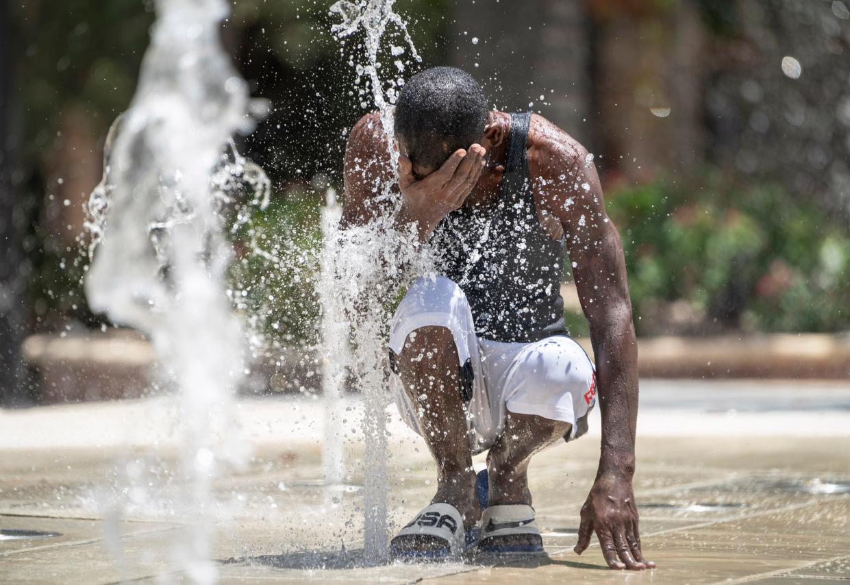 Roderick Underwood cools off in the Centennial Fountain during an excessive heat warning in West Palm Beach, Florida on August 8, 2023.