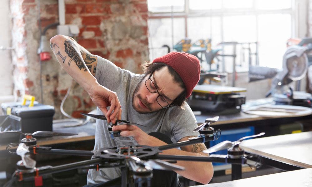 Male designer assembling drone in workshop