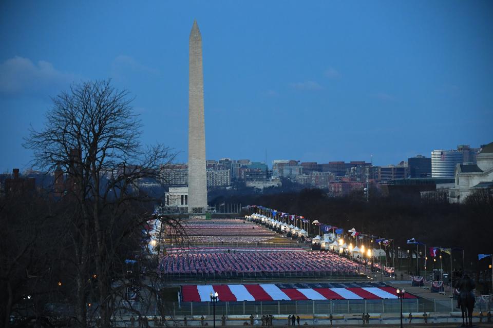 The National Mall is illuminated as the sun begins to rise before the 2021 Presidential Inauguration at the U.S. Capitol on Jan. 20, 2021.