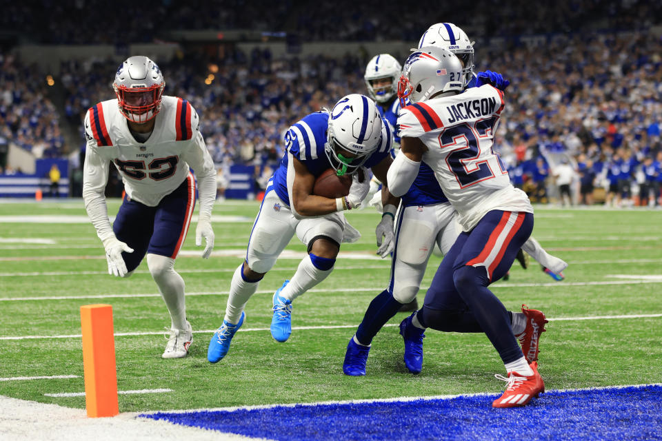 Indianapolis Colts running back Nyheim Hines, center, scores between New England Patriots cornerback J.C. Jackson (27) and middle linebacker Kyle Van Noy (53) during the first half of an NFL football game Saturday, Dec. 18, 2021, in Indianapolis. (AP Photo/Aaron Doster)