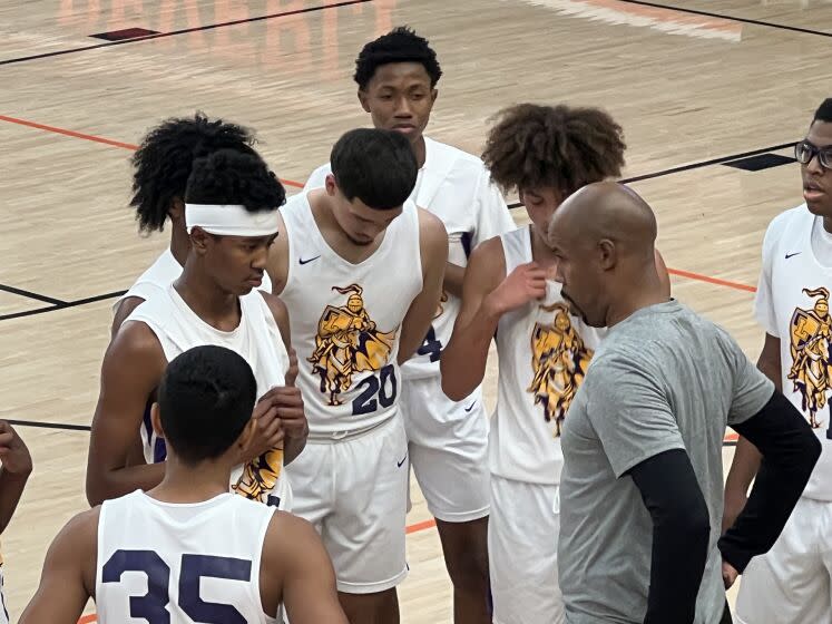 Lynwood coach Jason Crowe Sr. talking to his son, freshman Jason Crowe Jr. (headband).