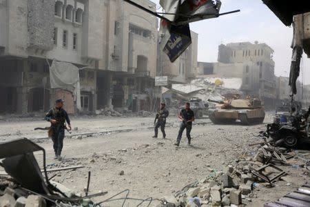 Members of Iraqi federal police run with their weapons during fighting with Islamic State militants at the frontline in the Old City of Mosul, Iraq July 7, 2017. REUTERS/Ahmed Saad