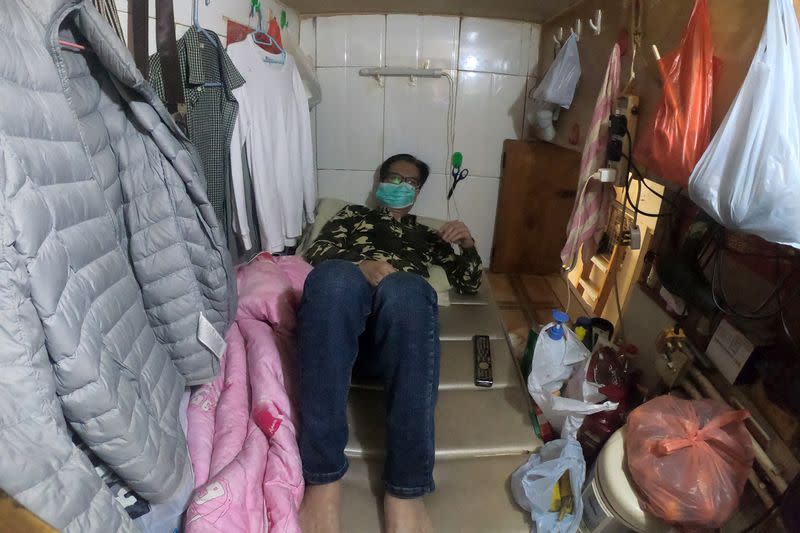 Simon Wong, 64, wears a protective mask as he rests at his 2 square metre subdivided residential unit, known as a "coffin home", following the outbreak of the new coronavirus, in Hong Kong