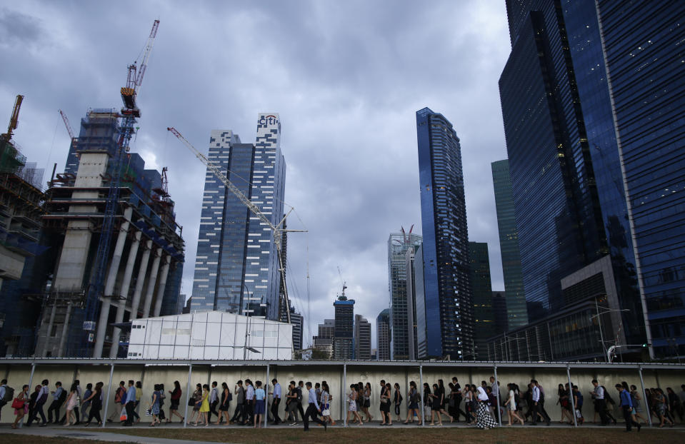 Office workers walk to the train station during evening rush hour in the financial district of Singapore March 9, 2015. REUTERS/Edgar Su (SINGAPORE - Tags: SOCIETY CITYSCAPE TRANSPORT TPX IMAGES OF THE DAY BUSINESS CONSTRUCTION)