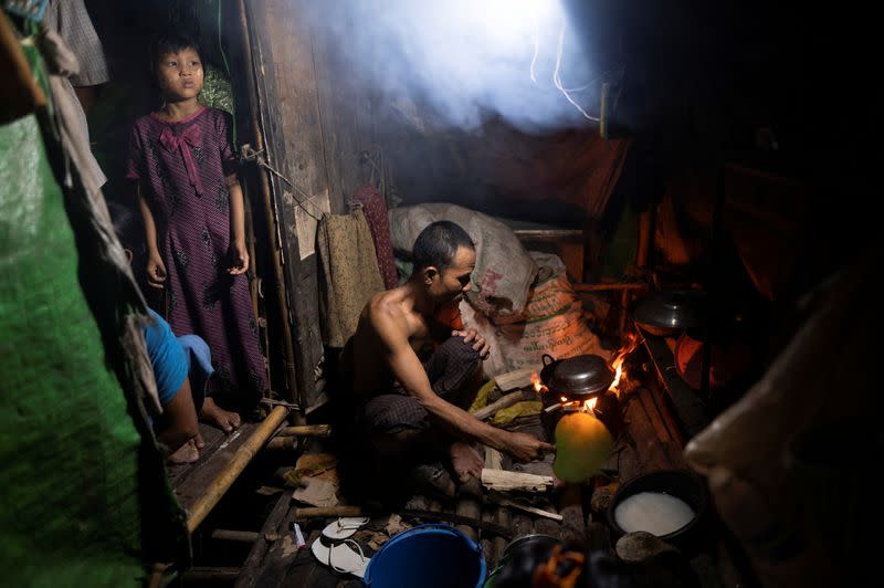 Man cooks dinner in Yangon shanty during coronavirus lockdown