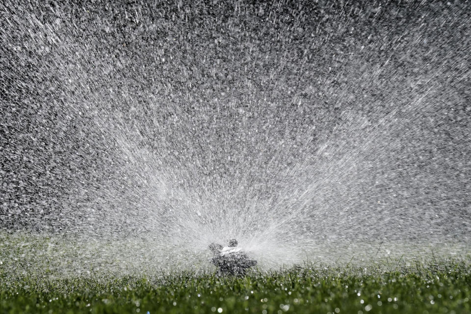 FILE - Water flies from a sprinkler watering a lawn in Sacramento, Calif., on May 10, 2022. Cities and farms that rely on state water supplies will get 5% of what they requested in the new year, state water officials announced Thursday, Dec. 1, 2022. (AP Photo/Rich Pedroncelli, File)