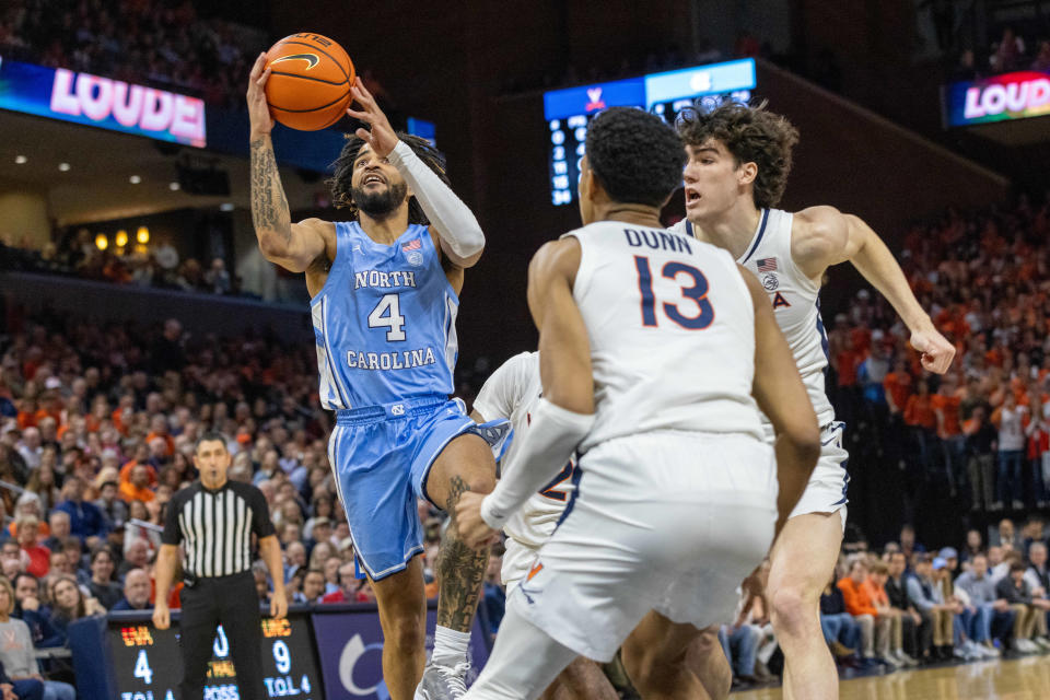 Feb 24, 2024; Charlottesville, Virginia, USA; North Carolina Tar Heels guard RJ Davis (4) attempts a shot while Virginia Cavaliers Ryan Dunn (13) and Blake Buchanan (0) defend him during the first half at John Paul Jones Arena. Mandatory Credit: Hannah Pajewski-USA TODAY Sports