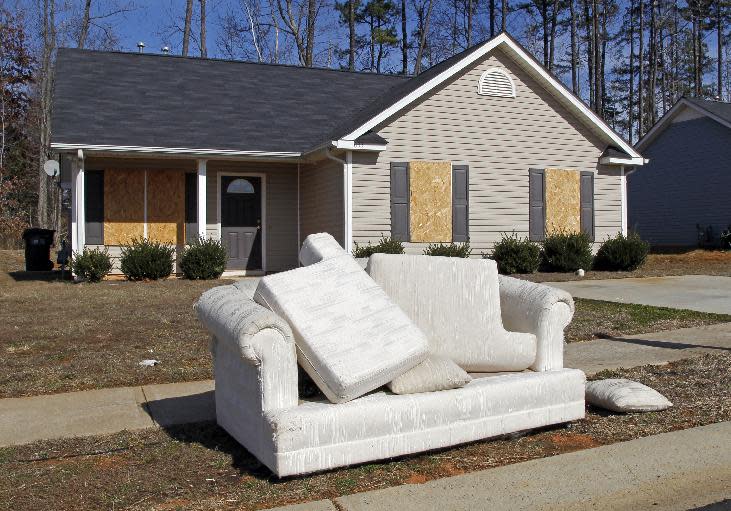 FILE - This Tuesday, Feb. 15, 2011 file photo shows a discarded sofa in front of an abandoned house in the Windy Ridge subdivision of Charlotte, N.C. In 2008, Obama became the first Democrat to take North Carolina since Jimmy Carter in 1976. Pundits called the victory historic, but it came by the slimmest of margins _ just 14,000 votes out of nearly 4.4 million cast. History suggests that if the economy doesn't show substantial improvement in the year before a presidential election, the incumbent loses. And North Carolina's recovery from the "Great Recession" has lagged behind the nation's. (AP Photo/Bob Leverone, File)