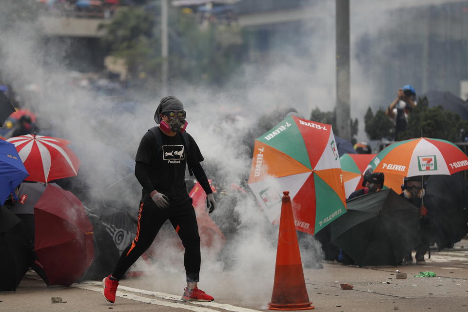 Protestors face tear smoke from police in Hong Kong, Sunday, Sept. 29, 2019. Riot police fired tear gas Sunday after a large crowd of protesters at a Hong Kong shopping district ignored warnings to disperse in a second straight day of clashes, sparking fears of more violence ahead of China's National Day. (AP Photo/Vincent Thian)