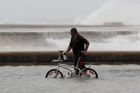 A man pushes his bike through a flooded street after the passing of Hurricane Irma, in Havana, Cuba, September 10, 2017. REUTERS/Stringer