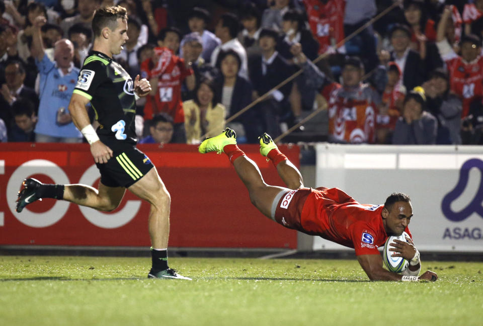 Sunwolves' Semisi Masirewa, right, scores a try against the Hurricanes defense during the Super Rugby match between the Hurricanes and Sunwolves in Tokyo, Friday, April 19, 2019. (AP Photo/Shuji Kajiyama)