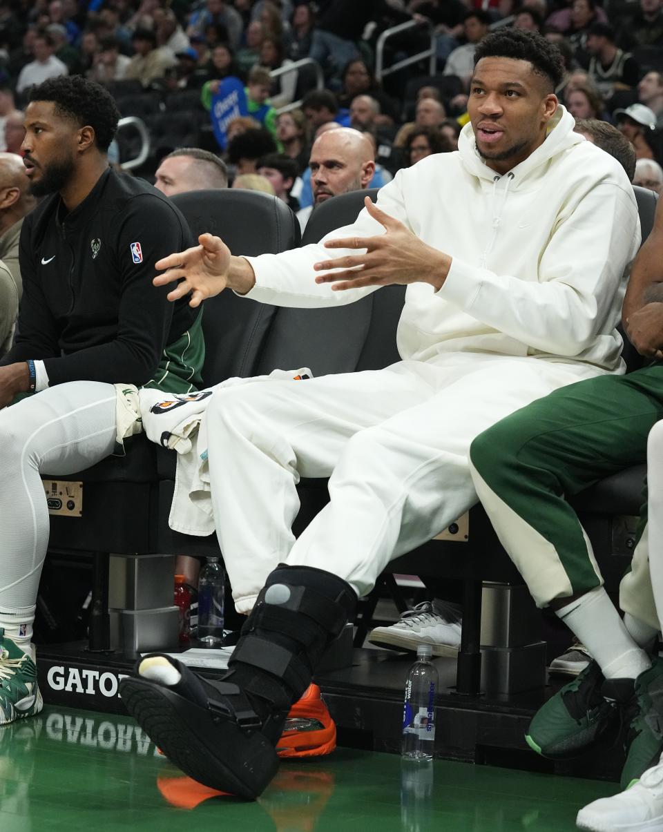 Milwaukee Bucks forward Giannis Antetokounmpo watches the Bucks-Magic game Wednesday night with a walking boot on his left foot.  Antetokounmpo strained his calf Tuesday night.