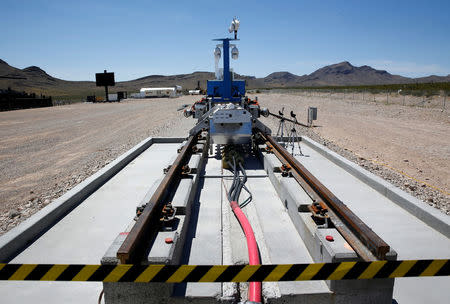 A silver-colored sled (C) is displayed on a test track after a propulsion open-air test at Hyperloop One in North Las Vegas, Nevada U.S. May 11, 2016. REUTERS/Steve Marcus