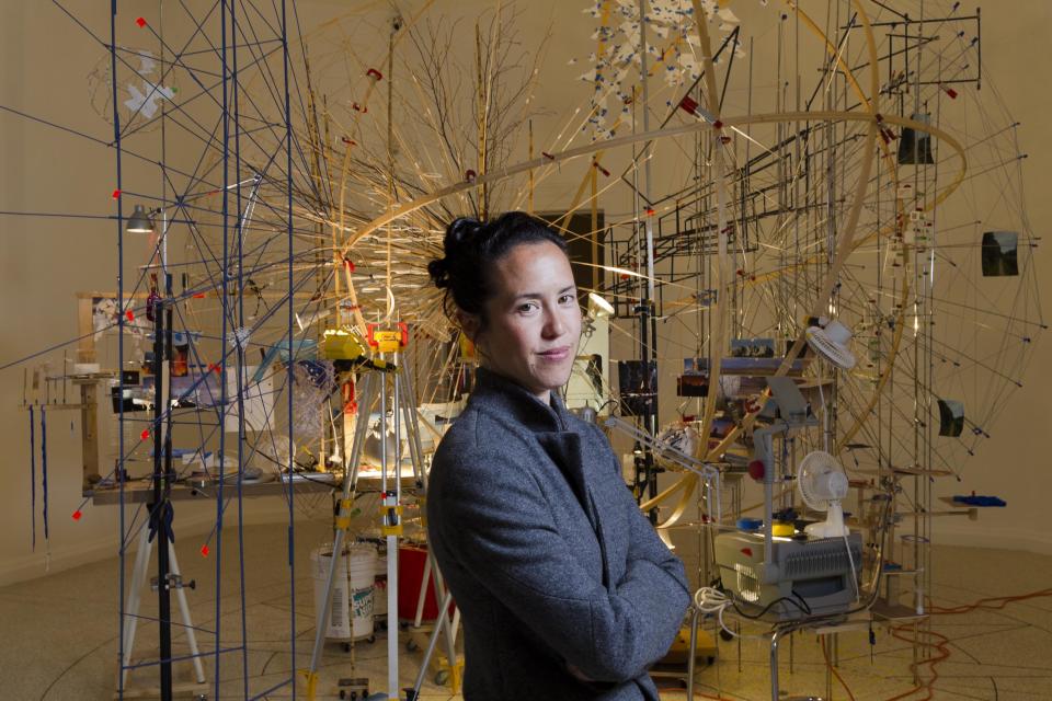 In this photo taken on Tuesday, May 28, 2013, artist Sarah Sze poses in front of the installation 'Planetarium' part of her project 'Triple point' on display at the U.S. Pavilion, during a press preview of the 55th edition of the Venice Biennale of Arts in Venice, northern Italy. (AP Photo/Domenico Stinellis)