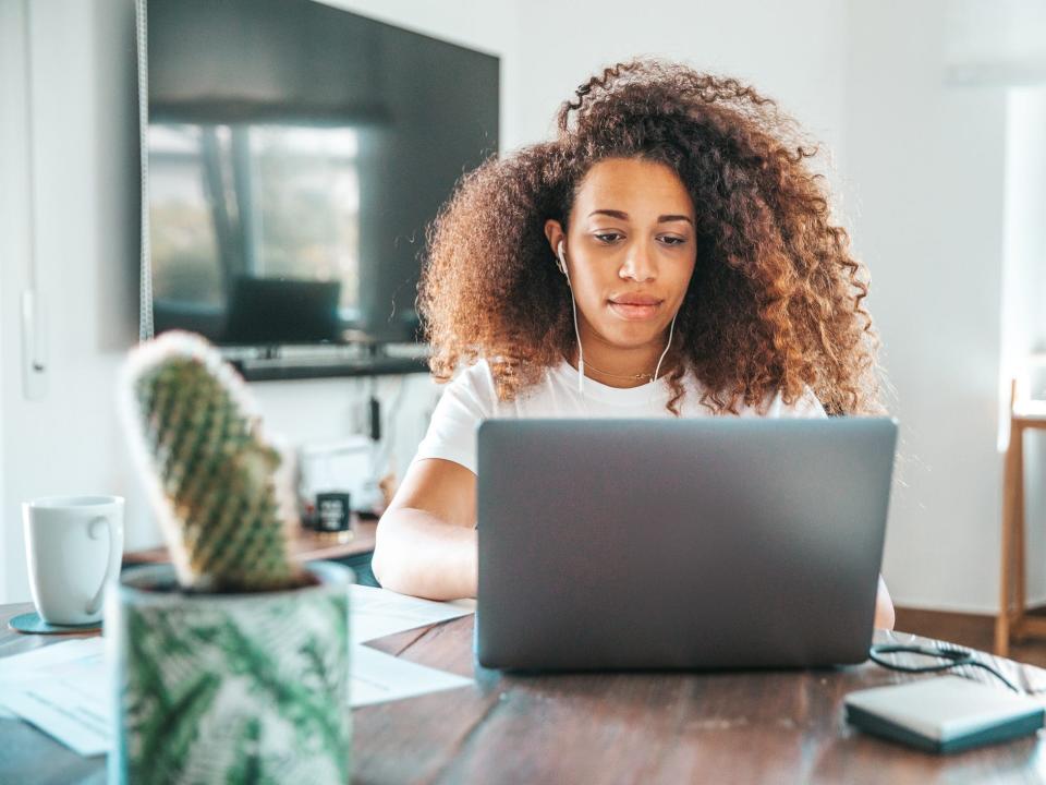 person working on a laptop wearing headphones