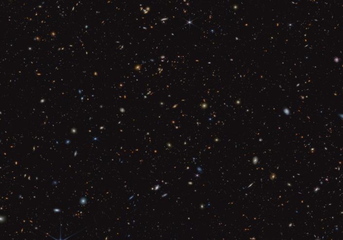 James Webb Space Telescope image showing 45,000 galaxies as tiny splashes of light against the black void of deep space.