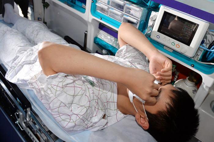 躺在救護車上，T.O.P用雙手護臉，似乎不想再被媒體關注。