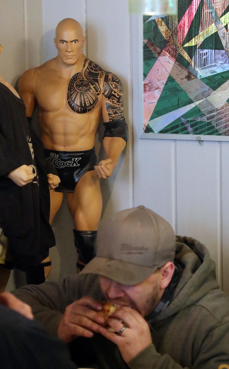 An action figure of WWE Superstar Dwayne "The Rock" Johnson appears to watch customers eat lunch at Akron's Diamond Deli on Jan. 26.