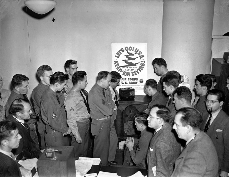 Members of the staff of a U.S. Army recruiting station gather around a radio to listen to U.S. President Franklin Roosevelt's special message broadcast on the radio in Boston, Ma., Dec. 8, 1941.  The president's message to a joint session of Congress asks for a declaration of war against Japan.