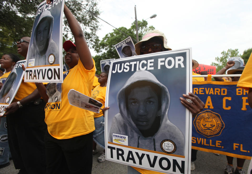 FILE- In this March 31, 2012 file photo, protestors hold up signs in a march and rally for slain Florida teenager Trayvon Martin in Sanford, Fla. The death of Martin and later 2013 trial and acquittal of George Zimmerman raised questions about race, gun control and justice in America. (AP Photo/Julie Fletcher, File)