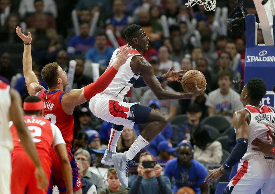 Washington Wizards guard Isaac Bonga, center, goes to the basket past Detroit Pistons forward Blake Griffin (23) during the first half of an NBA basketball game Thursday, Dec. 26, 2019, in Detroit. (AP Photo/Duane Burleson)