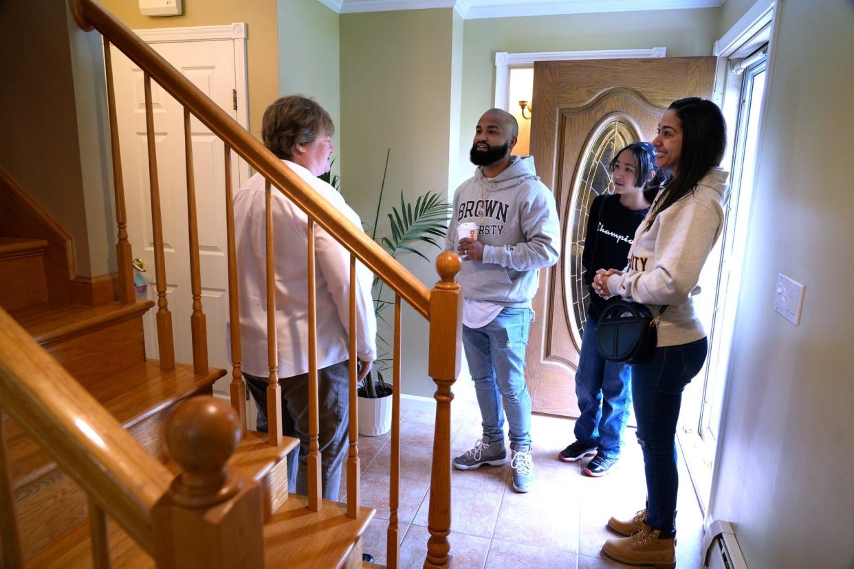 Listing agent Anne McCrann, left, greets the Martinez family of North Providence – Jose, daughter Rosalynn and wife Maureen, during a 2022 open house in Johnston.  [Kris Craig/Providence Journal, file]