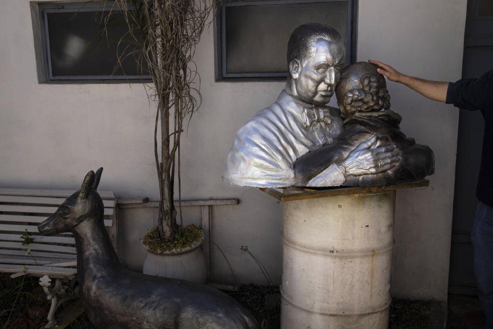 A bust depicting Juan Domingo Perón, three-time president of Argentina, and his wife Eva “Evita” María Duarte, in an embrace, sits on a piece of wood atop a barrel, on the patio of the artist Héctor Duarte's family home, in San Miguel, Argentina, Tuesday, Nov. 1, 2022. A cement tear runs down the cheek of Evita who was known as the "flag-bearer of the poor”, evoking the historic moment in which a cancer-stricken Evita tells the crowd gathered for a public act in 1951 that she will not accompany her husband as his vice presidential candidate. After her early death in 1952, she became enshrined in Argentina’s national mythology. (AP Photo/Rodrigo Abd)