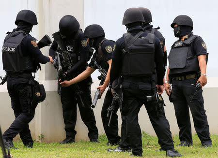 Special Weapons and Tactics (SWAT) team members prepare tear gas to disperse various activist and Indigenous People's (IP) groups protesting against the continuing presence of U.S. troops in the Philippines in front of the U.S. Embassy in metro Manila, Philippines October 19, 2016. REUTERS/Romeo Ranoco