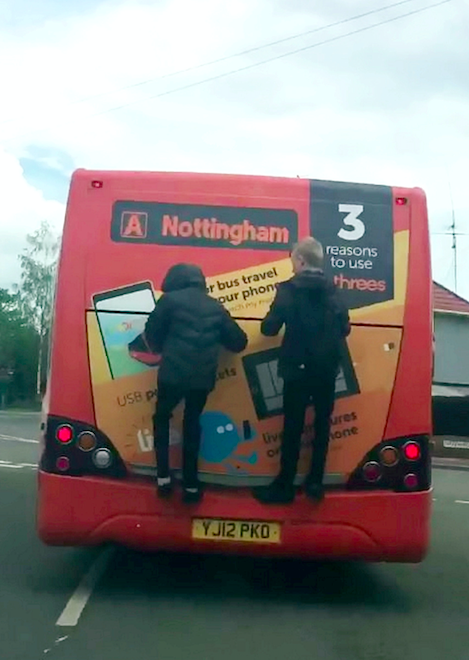 The youngsters precariously held on to the back of the vehicle for more than a minute. (SWNS)