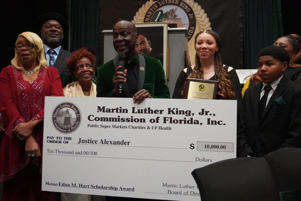 Rodney Long, center, founder of the Martin Luther King Jr. Commission of Florida Inc., presents a $10,000 Edna M. Hart Keeper of the Dream Scholarship check to Justice Alexander, on the right of Long, during the annual King Commission Hall of Fame Gala on Sunday.
(Credit: Photo by Voleer Thomas, Correspondent)